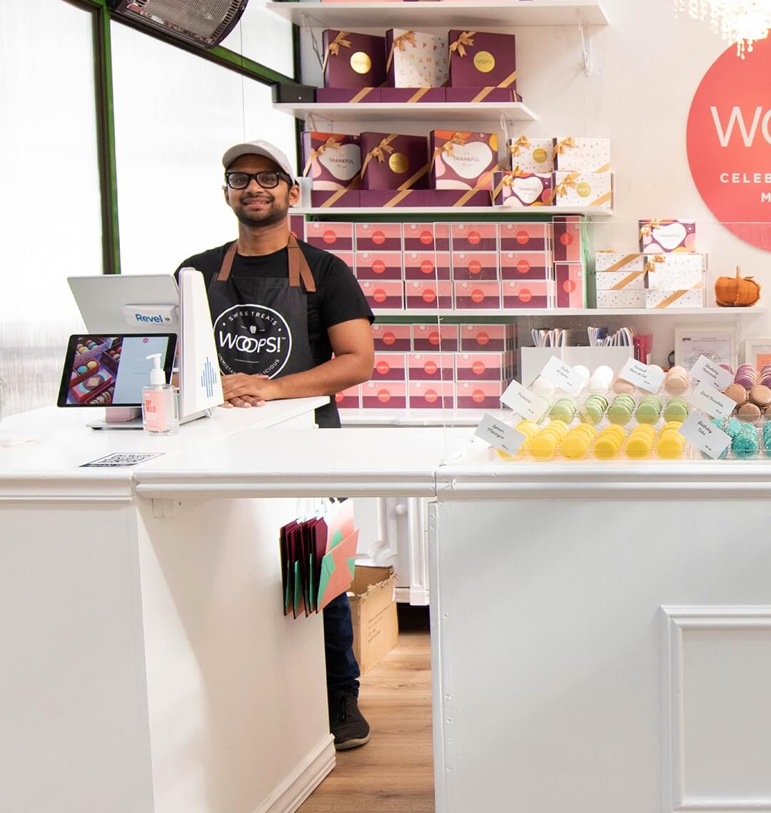 Woops! Booth at Bryant Park filled with colorful macarons and a smiling man behind the counter