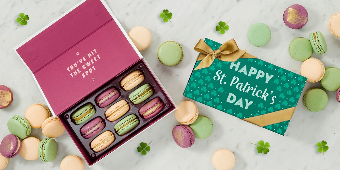Woops! macaron box featuring Vanilla, Pistachio, and Honey Lavender flavors, packaged with a St. Patrick's Day sleeve