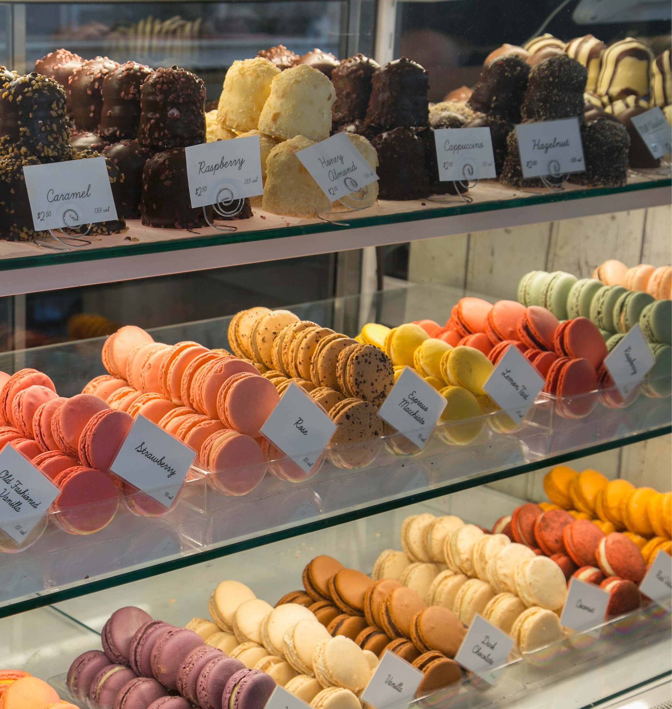 Woops! counter filled with assorted French macaron flavors and cremebellos