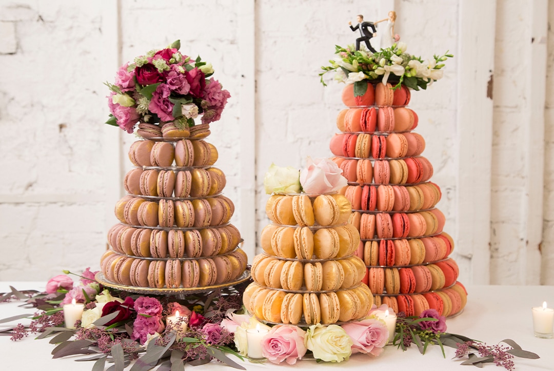 Different size French macaron pyramids with flowers decorating
