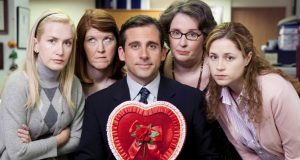  A man holding a heart-shaped box is surrounded by women. ​​https://www.goodhousekeeping.com/life/entertainment/g30912004/the-office-valentines-day-episodes/ 