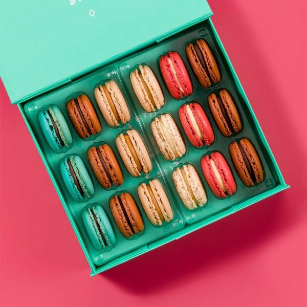 A green Woops! French macaron box full of Dark Chocolate, Nutella, Red Velvet, Mint Chocolate, Cookies & Cream, and Caramel Fleur de Sel macarons.