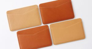 Four brown and beige leather card cases with white background.