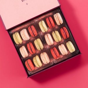A box full of 18 Vanilla, Raspberry, and Strawberry Lemonade French macarons.