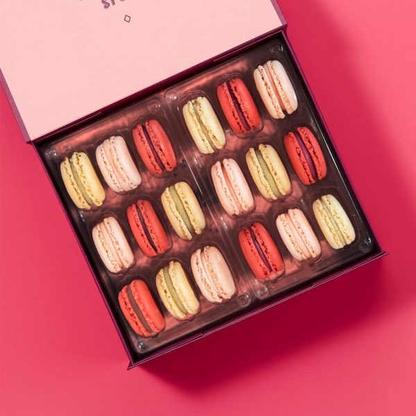 A box full of 18 Vanilla, Raspberry, and Strawberry Lemonade French macarons.