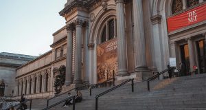 Entrance to the MET Museum of New York composed of wide stairs and a beautiful antique entrance.