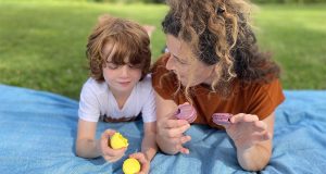 A woman and her son are holding French macarons in their hands