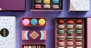 Numerous boxes full of assorted French macarons and French macaron boxes. 