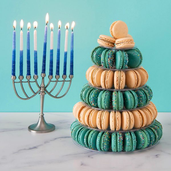 A macaron pyramid with Vanilla and Birthday Cake macarons has a menorah to the left.