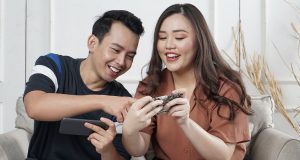 A smiling man and woman are looking at a cellphone