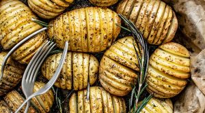 Bowl full of roasted potatoes and forks.