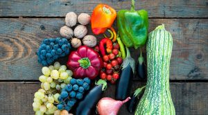 Assorted vegetables and fruits on a wooden table.