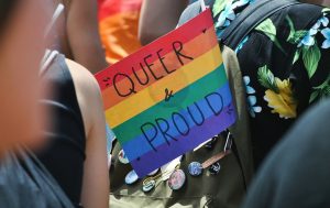 Pride flag with “Queer & Proud” written on it.