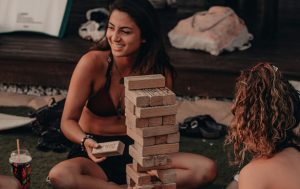 Two smiling women playing Jenga. 