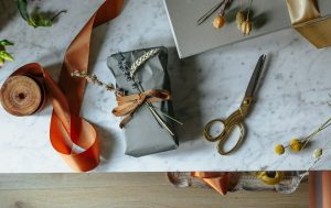 Gift wrapping essentials like scissors, paper, flowers, and ribbon.