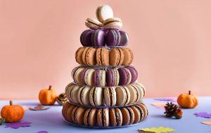 A French macaron pyramid surrounded by acorns, leaves, and tiny pumpkins. 