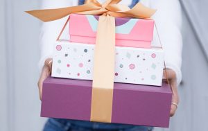 Someone holding three gift boxes. 