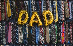 yellow balloon letters spelling out "DAD" with ties background.